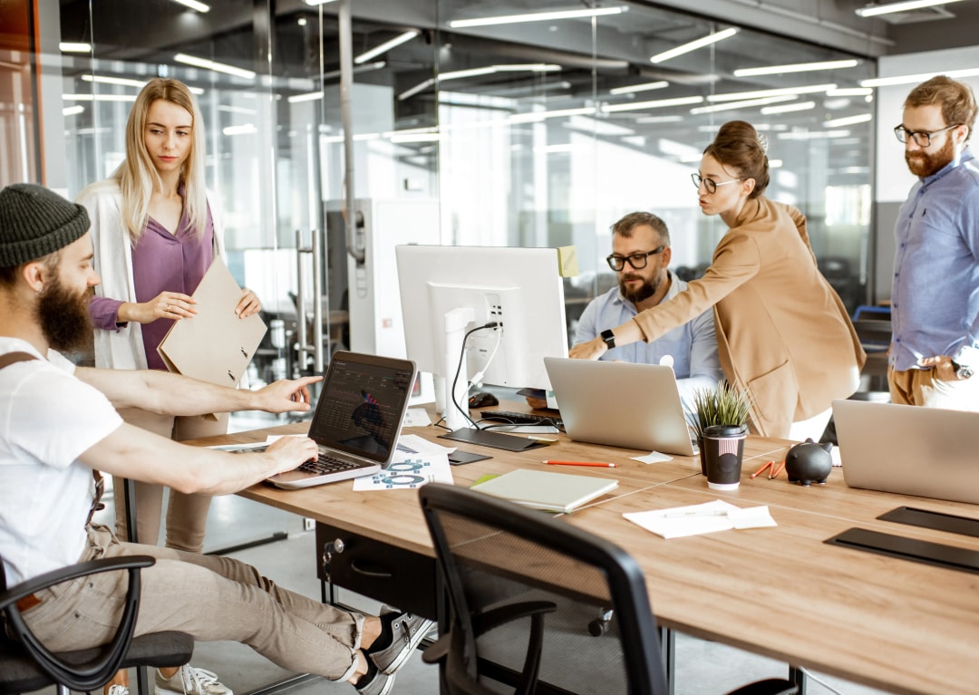 Professionnels en réunion au bureau pour discuter d’un prêt professionnel et de son assurance