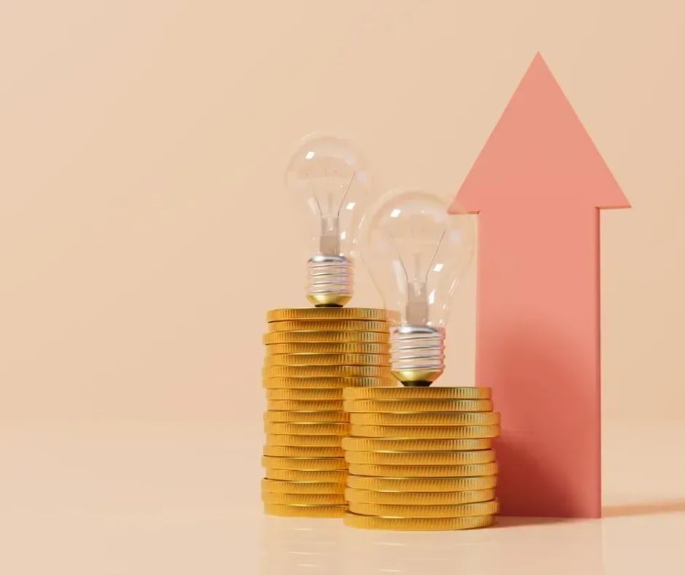Ampoule et flèche pointant vers des euros pour illustrer l’importance de comparer le prix de l’assurance emprunteur et les économies possibles sur le coût total du crédit immobilier