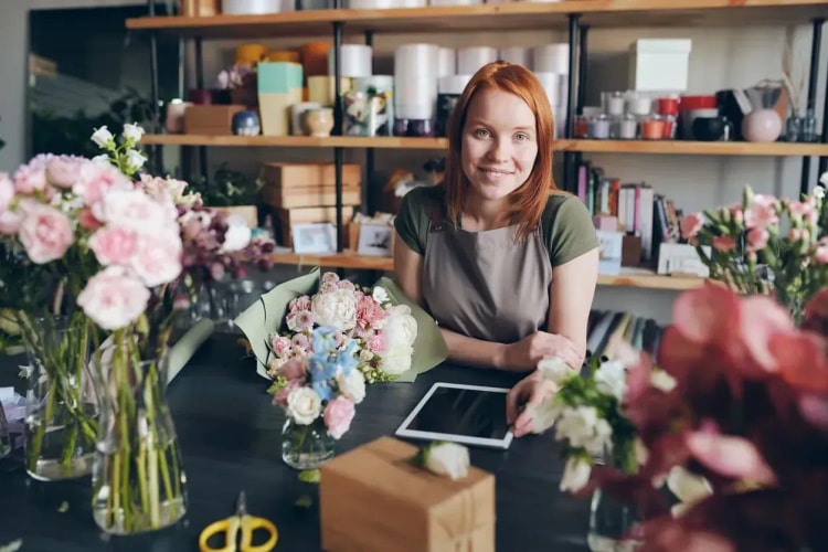 Fleuriste entrepreneur examinant une demande de prêt professionnel pour financer son commerce