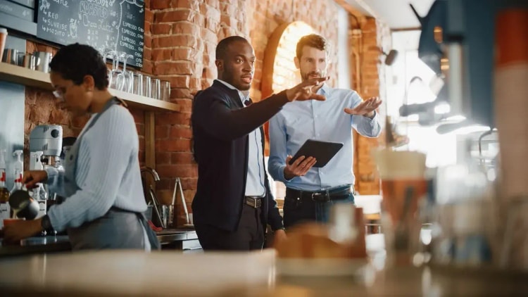 Propriétaire de restaurant discutant d’un prêt professionnel et d’une assurance adaptée