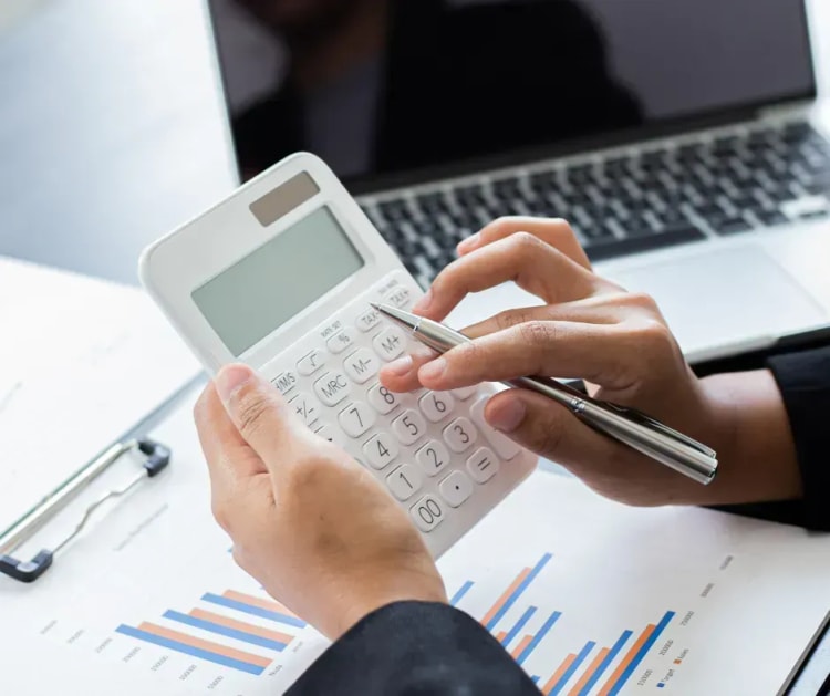 Calculatrice posée sur des documents, illustrant les économies possibles grâce à la loi Lemoine sur l’assurance emprunteur
