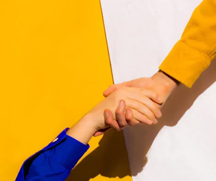 Deux personnes se serrant les mains pour illustrer la solidarité et la protection offerte par l’assurance perte d’emploi dans le cadre d’un crédit immobilier