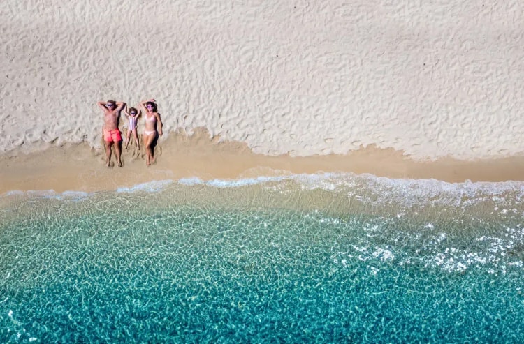 Scène de plage animée avec des vacanciers, représentant l'impact du pouvoir d'achat sur les dépenses de loisirs pendant les vacances d'été